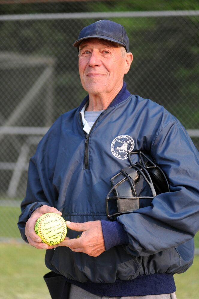 Dan Clark, a graduate of the Liberty High School Class of 1964, is retiring after 45 years spent officiating local baseball, soccer and softball games. He is pictured holding a softball signed by the Sullivan West varsity softball team.....